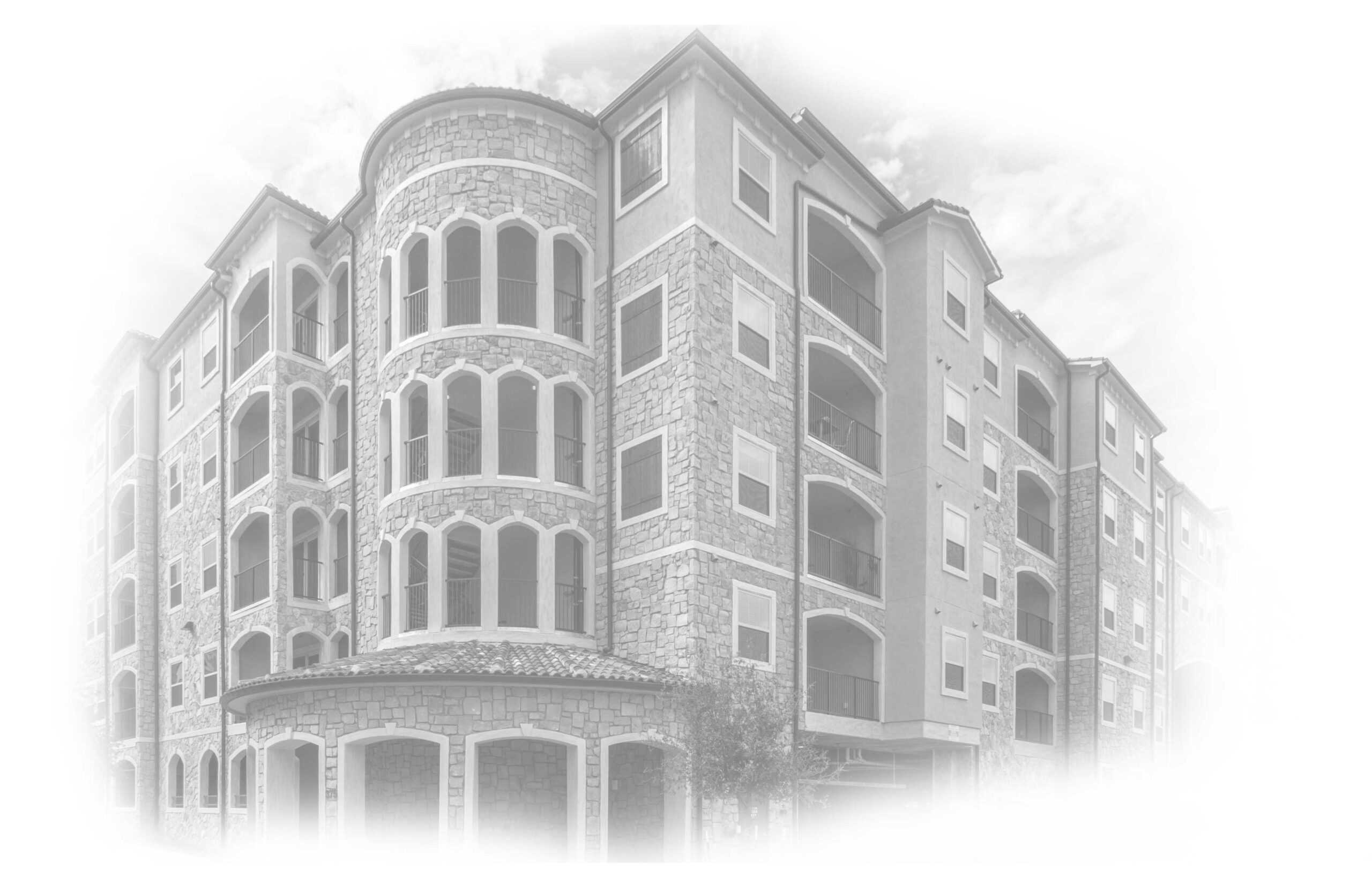 Black and white image of a Mediterranean-style multi-story residential building with stone accents and large arched windows, showcasing intricate architectural details under a partly cloudy sky.